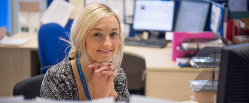 HR team member sitting in office smiling.