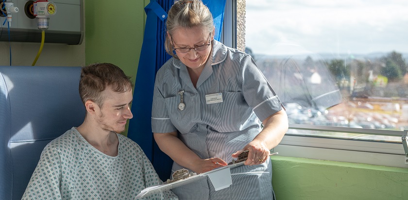 Female nurse showing male patient medical notes