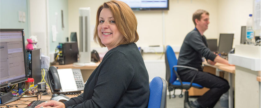 Smiling female member of staff at a computer