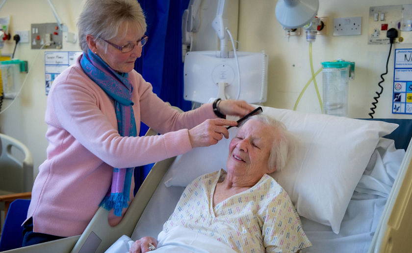 Carer brushing patients hair