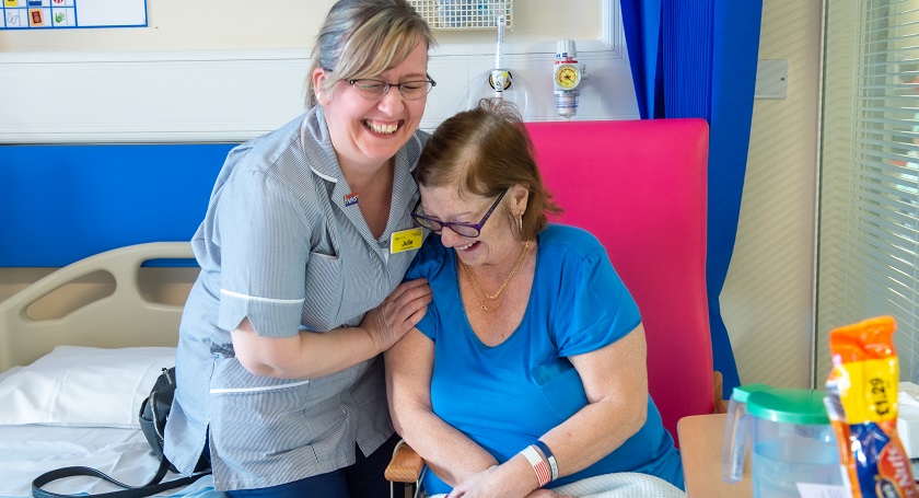 Female nurse with female patient, they are both laughing