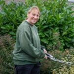 A gardener cutting the hedge