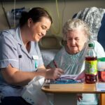 A nurse sitting with a patient