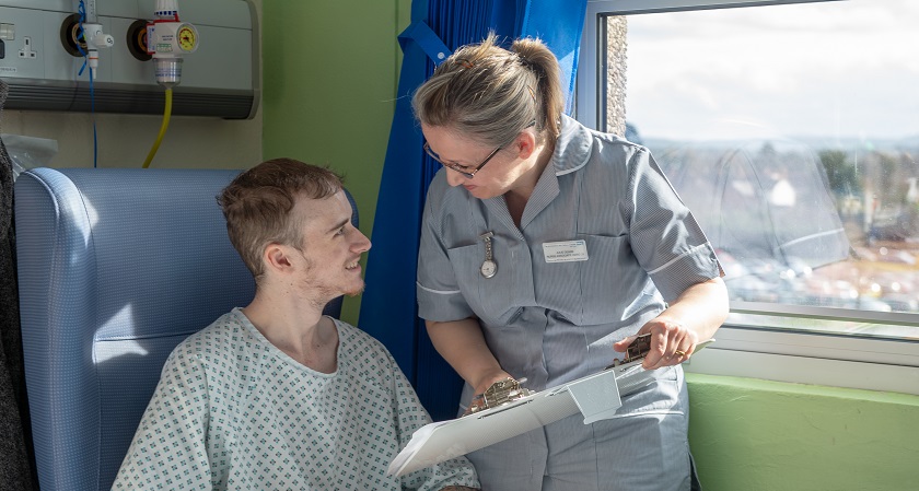 Female nurse and male patient smiling at each other