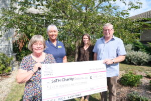 Former patient Jonathan Mills and his wife Ann present £750 cheque to the Colorectal Department - Julie Powell and Kirsten McArdle