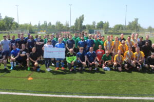 Player from Football Tournament holding the big charity cheque