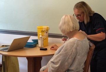 Care Home resident Julie Hayes receiving her vaccination from Linda Hart, Clinical Team Lead