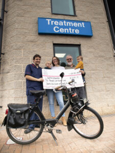 Ian Mair, his daughter Kathryn and his grandchildren present Peter Warren, Ward Manager with a cheque