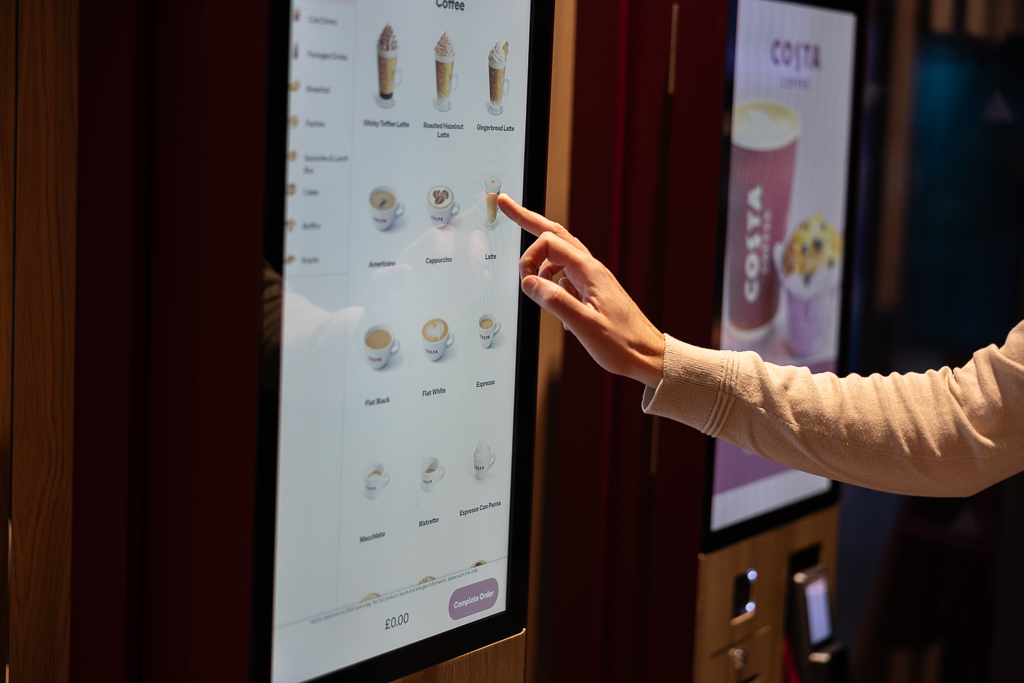 Customer using the self-service kiosk at the new Costa Coffee store at PRH
