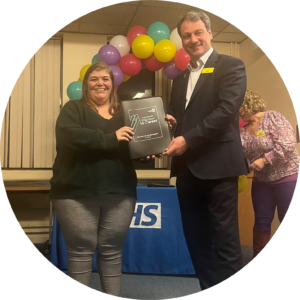 Image of Bailey Thompson receiving her volunteer to career certificate from Nigel Lee, Exec Director of Strategy and Partnerships