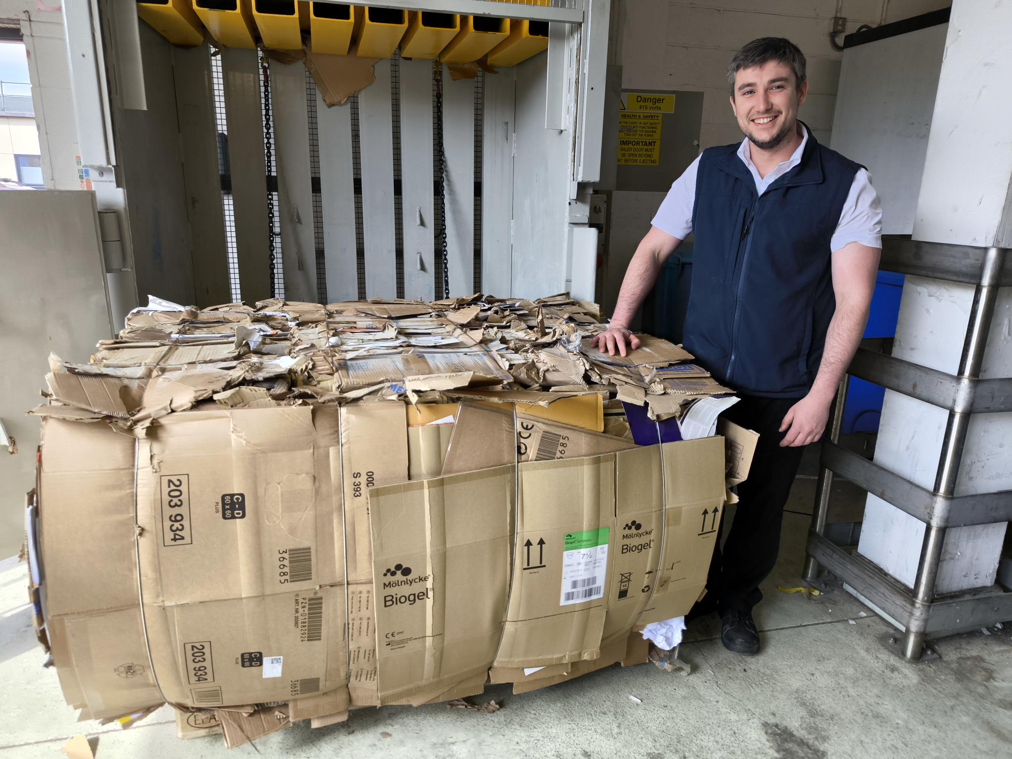 Jake Mound-Evans, a Chargehand Porter, with one of the cardboard bales