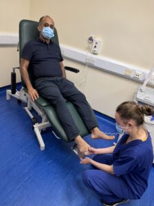 2. Claire Atherton using the mirror to look at a patient's foot