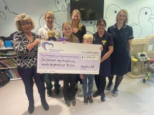 An image of Henrietta and staff from Shrewsbury and Telford Hospital NHS Trust holding the big charity cheque