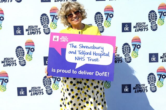 Julia DofE 2 Julia Clarke, Director of Public Participation, holding a sign saying "The Shrewsbury and Telford Hospital NHS Trust is proud to deliver D of E (short for the Duke of Edinburgh Award)